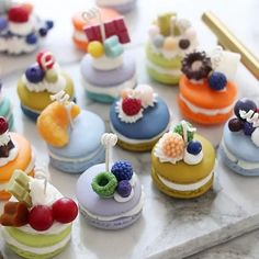 there are many small cupcakes on the table together, all decorated in different colors