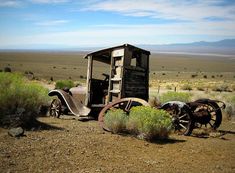 an old truck sitting in the middle of nowhere