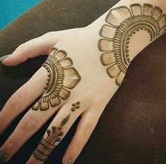 a woman's hand with henna tattoos on it