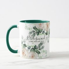 a coffee mug with white roses and green leaves on the inside, reads bridesmaid