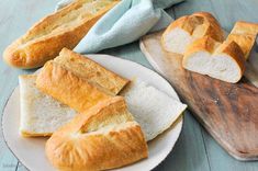 several pieces of bread on plates next to a cutting board