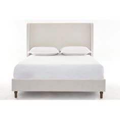 a white bed with two pillows on the headboard and one pillow in the middle