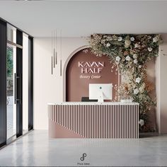 the front desk of a beauty center with flowers and greenery on it's wall