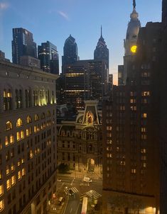 the city skyline is lit up at night, with skyscrapers in the background and street lights on