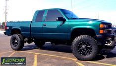 a green truck parked in a parking lot