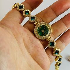 Technical specifications: ➡ Movement: Quartz ➡ Case Material: Gold colour metal ➡ Dial : Green ➡ Band: Green Gemstones Band ➡ Case Shape: Round ➡ Case Diameter: 25 mm ➡ Band Width: 14mm ➡ Display: Analog ✈ Free Shipping **Green stones on the band have no material value.** Discover the epitome of elegance with this gold women's watch, a stunning piece that seamlessly blends classic luxury with modern style. Featuring a vibrant emerald green dial surrounded by sparkling crystals, this unique watch for women is perfect for those who appreciate vintage-inspired designs. Whether you're looking for a dainty women's watch that adds a touch of sophistication to your outfit or a statement piece that stands out, this timepiece delivers it all. Crafted with meticulous attention to detail, this watch Gold Watch For Women, Gold Womens Watch, Emerald Watch, Dainty Watch, Vintage Gold Watch, Watch Green, Flower Watch, Gold Watches Women, Watch Gift