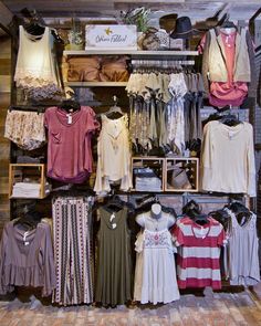 an assortment of women's clothing on display in a store