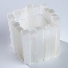 a white object is sitting on a table and looks like it's made out of ice cubes