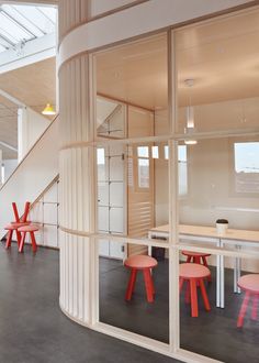 the inside of a building with tables and stools