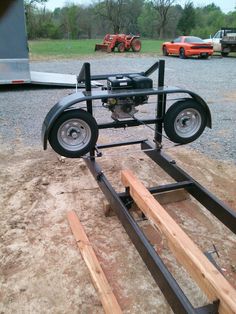 an engine is attached to the back of a trailer with two wooden boards on it