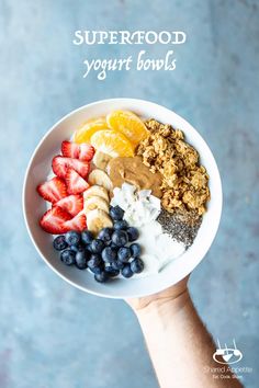 a person holding a bowl of fruit and yogurt with the words superfood yogurt bowls above it