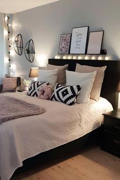 a bed with pillows and blankets on top of it in a room filled with lights