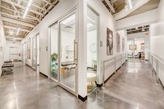 an office with glass walls and lots of white furniture