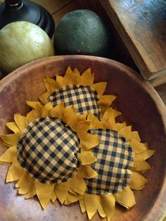 two sunflowers are sitting in a wooden bowl