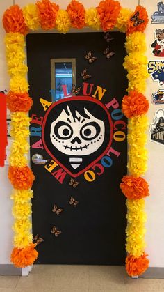 a door decorated with flowers and decorations for the school's day of the dead celebration