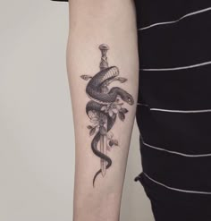 a snake and dagger tattoo on the arm