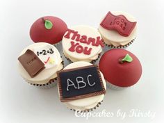 cupcakes with writing on them are arranged in the shape of an apple and teacher's chalkboard