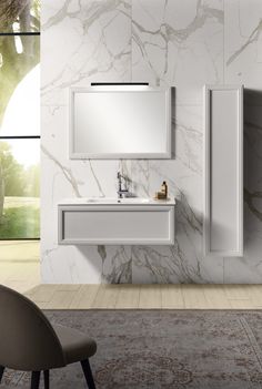 a modern bathroom with marble walls and flooring, including a white sink and mirror