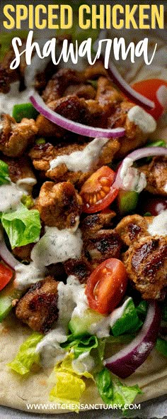 a chicken shawarma with lettuce, tomatoes and onions