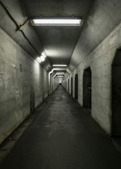 an empty tunnel with light at the end and no people in it on either side