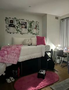 a bed room with a neatly made bed and pink rugs on the hardwood floor