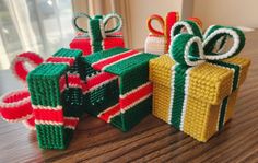 three wrapped gifts sitting on top of a wooden table next to each other with bows