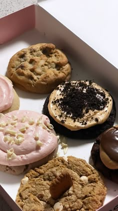 a box filled with lots of different types of cookies and doughnuts on top of each other