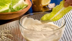 a glass bowl filled with yogurt and garnished with lettuce