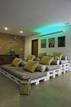 a room with couches made out of pallets and some yellow pillows on them