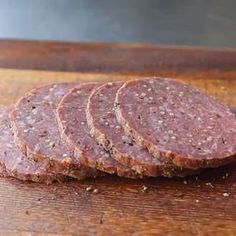 several slices of salami on a wooden cutting board