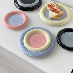 four plates with different designs on them sitting on a counter top next to each other