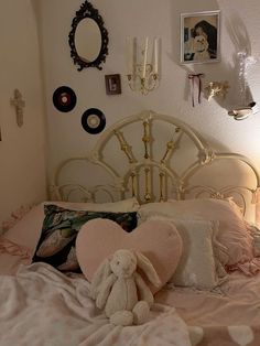 a white bed topped with pillows and a stuffed animal