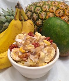 there are many different types of fruit in the bowl on the table, including bananas and pineapples