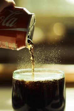 a beer being poured into a glass filled with liquid