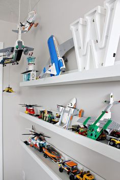 a room with shelves filled with legos and toy trucks on top of each shelf