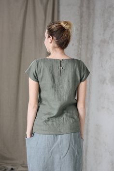 * 100% soft linen * Short sleeve * 2 buttons at the back * Handmade in Slovakia * The model is 176 cm tall, wearing size S, color Olive (this color is no longer available) Measurements: Size XS - cloth (laid on the floor): Bust: 42 cm Length (from the neckline to the hem measured from the back): 56 cm -------------------------- Size S - cloth (laid on the floor): Bust: 44 cm Length (from the neckline to the hem measured from the back): 58 cm --------------------------- Size M - cloth (laid on th Green Linen Crew Neck Top, Flax Cotton Top With Buttons, Flax Colored Tops With Buttons And Relaxed Fit, Cotton Buttoned Flax Top, Buttoned Flax Cotton Top, Cotton Flax Top With Buttons, Summer Tops In Flax Color With Buttons, Relaxed Fit Flax Top With Buttons, Relaxed Fit Flax Colored Top With Buttons