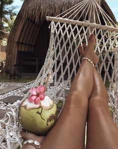 a person laying in a hammock with a coconut and flower decoration on it