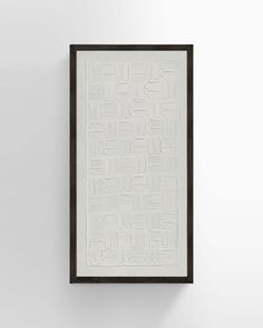 a white and black framed artwork hanging on the wall