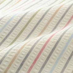 a close up view of a bed sheet with multicolored stripes