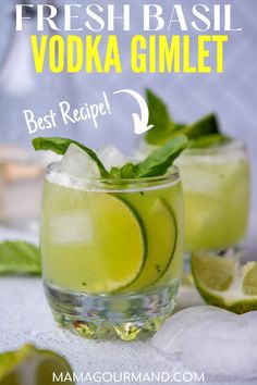 two glasses filled with lemonade and limes on top of a white tablecloth