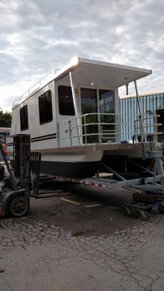 a truck with a house on it parked next to other vehicles and trucks in a parking lot