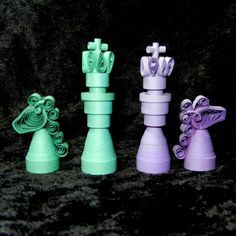 three different colored plastic chess pieces on a black background, one is green and the other is purple