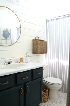 a white toilet sitting next to a sink in a bathroom under a mirror and a shower curtain