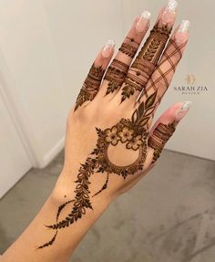 a woman's hand with henna tattoos on it