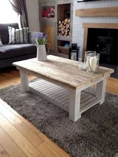 a white coffee table sitting on top of a wooden floor next to a gray couch