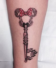 a person with a tattoo on their leg has a key in the shape of a heart