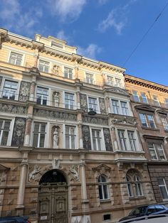 an old building with many windows on the front and side of it, along with parked cars