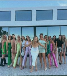 a group of women standing next to each other in front of a building