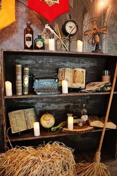 an old book shelf with candles, books and other items on it in a room