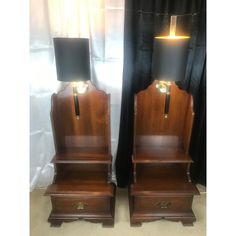 two wooden nightstands with lamps on top of them